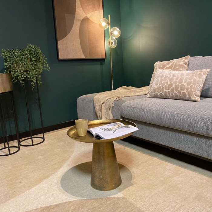 Gouden bijzettafel Daisy 50 cm met open boek naast een loungebank
