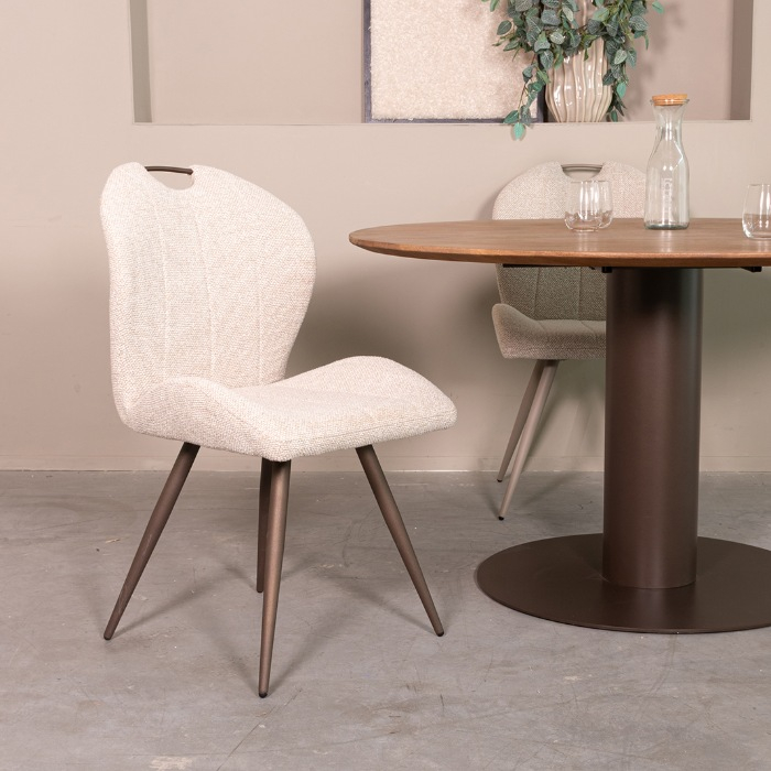 Eetkamerstoel Siem in crème bouclé met handvat, bronzen poten aan de eettafel