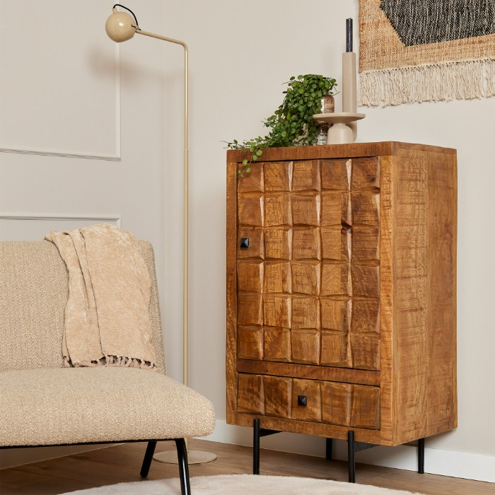 Mangohouten kastje Brandy met handgesneden blokjesfront naast een fauteuil