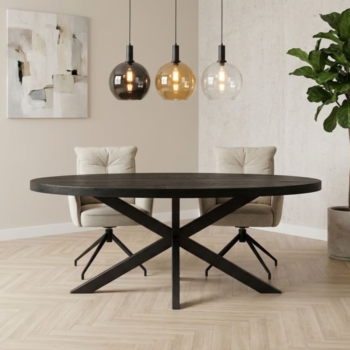 Ovale eettafel van zwart mangohout 180 cm met twee beige armstoelen en drie glazen hanglampen