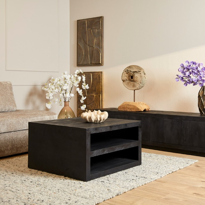 Zwarte mangohouten salontafel Brussel op wollen vloerkleed in lichte woonkamer