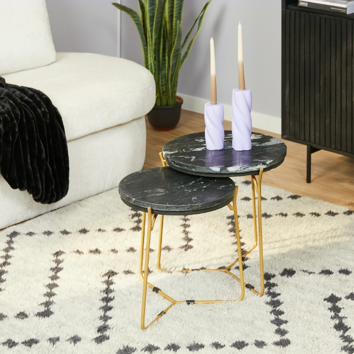 Ronde Caly salontafels met zwart marmer en gouden poten op een berber kleed