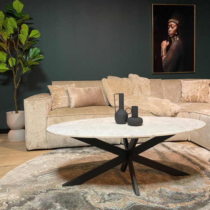 Ovale salontafel Faye met wit marmeren blad en zwart spinpoot onderstel in woonkamer
