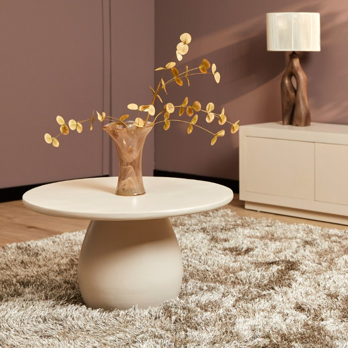 Ronde salontafel Mosi zand op hoogpolig vloerkleed met vaas en droogbloemen