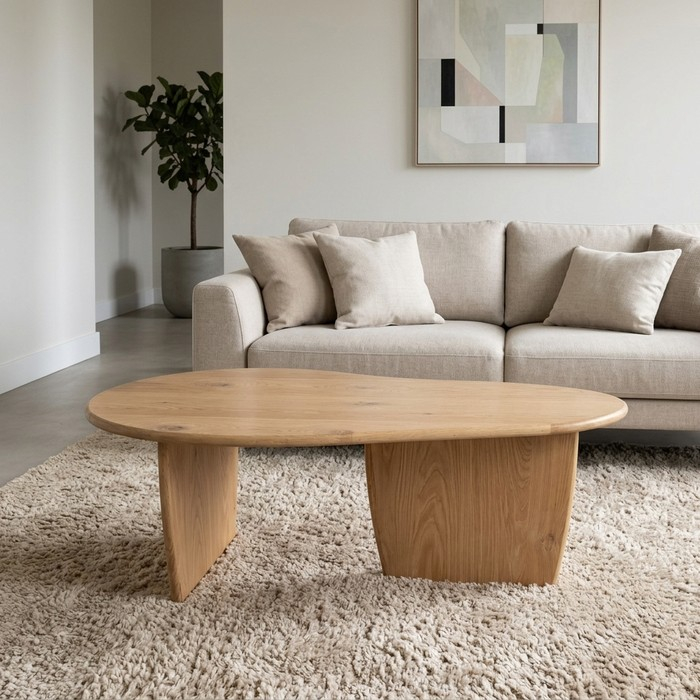 Eiken salontafel met organische vorm in een rustige woonkamer met bank en plant
