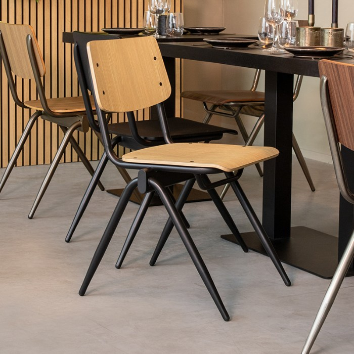 Stapelbare stoel Sven in naturel houtlook met zwart frame aan de eettafel
