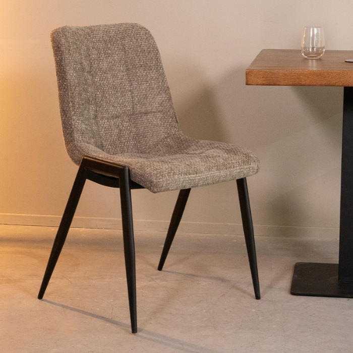 Stoffen eetkamerstoel Niels in olijfgroen met stiksels aan de eettafel