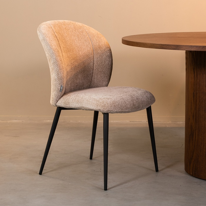 Stoffen eetkamerstoel Victor in beige met gebogen rug aan de eettafel