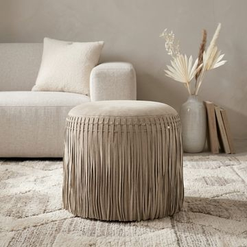 Leren poef met franjes in het taupe. 