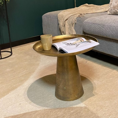 Ronde gouden bijzettafel Daisy 50 cm naast een grijze bank