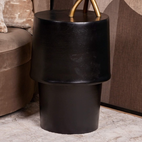 Ronde zwarte bijzettafel Kacy 36 cm naast een fluwelen fauteuil
