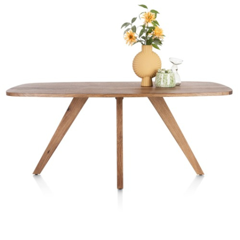 Deens ovale eettafel Everest 180 cm in mangohout op vier schuine houten poten, zijaanzicht met vaas en bloemen