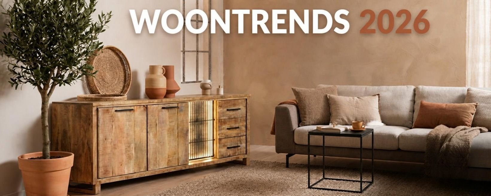 Woonkamer in warme aardetinten met een mangohouten dressoir met verlichting, een rieten schaal en terracotta vazen, een olijfboom in een terracotta pot en een zwarte salontafel