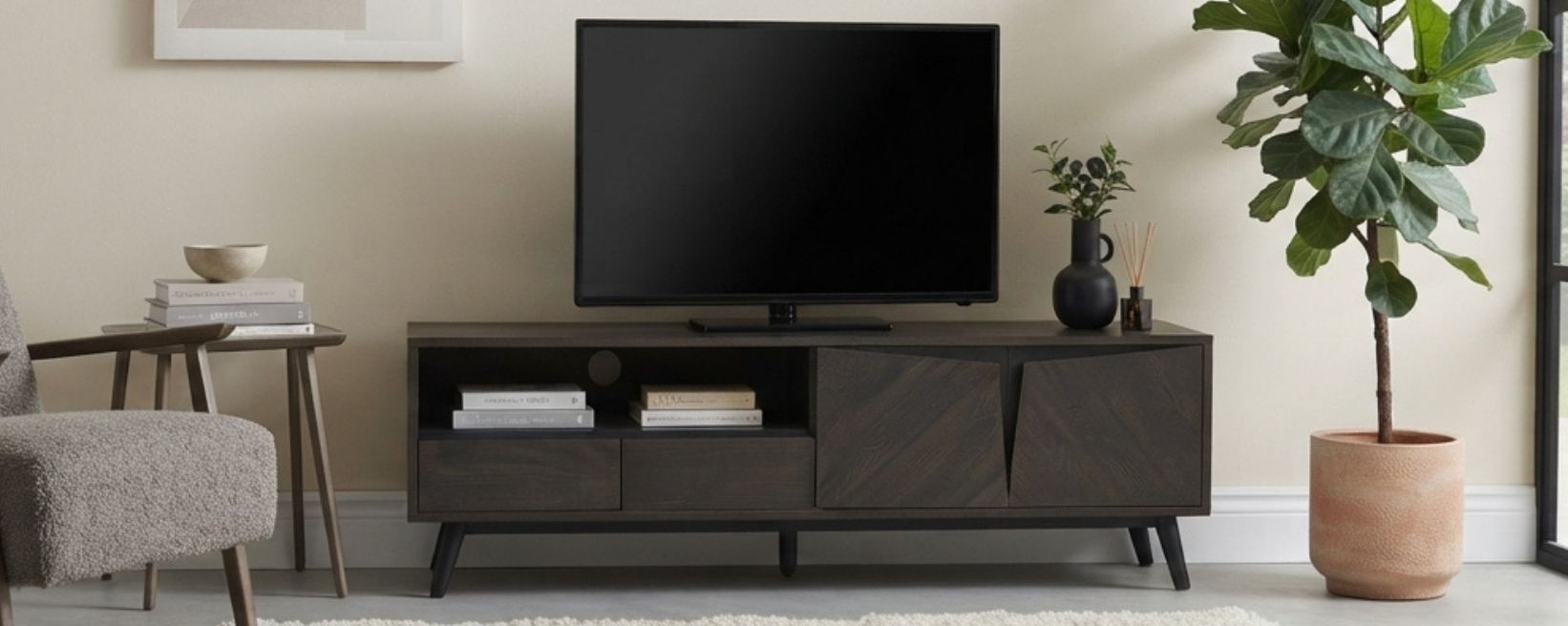 Woonkamer in mid-century stijl met donkerhouten tv-meubel, tv, grijze fauteuil, grote vioolbladplant en raam met uitzicht op de tuin.